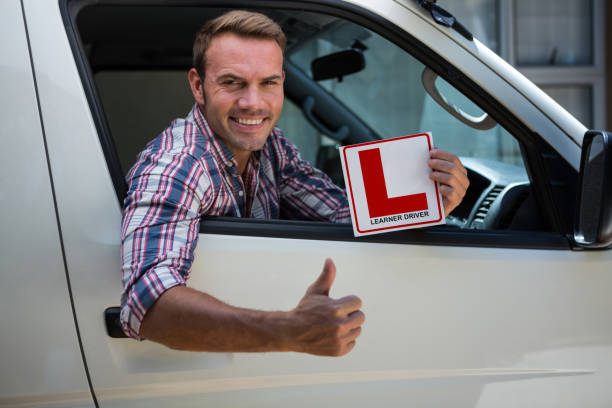 istock Young man gesturing thumbs up holding a learner driver sign 664888862