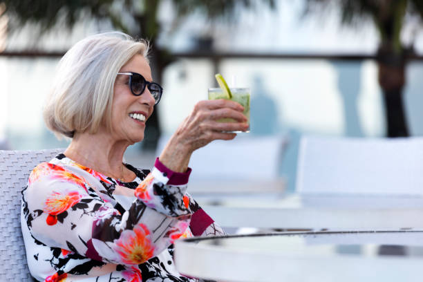 istock Elegant old lady drinking a caipirinha 664896368
