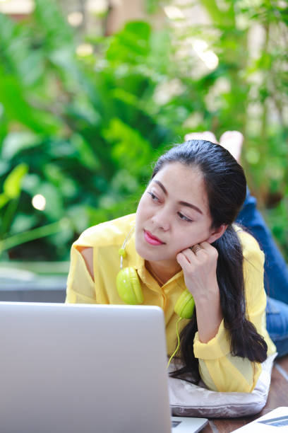 istock Asian woman using laptop computer with earphones. 664899642