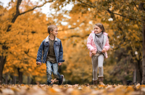 istock Two happy kids running in nature during autumn day. 664907254