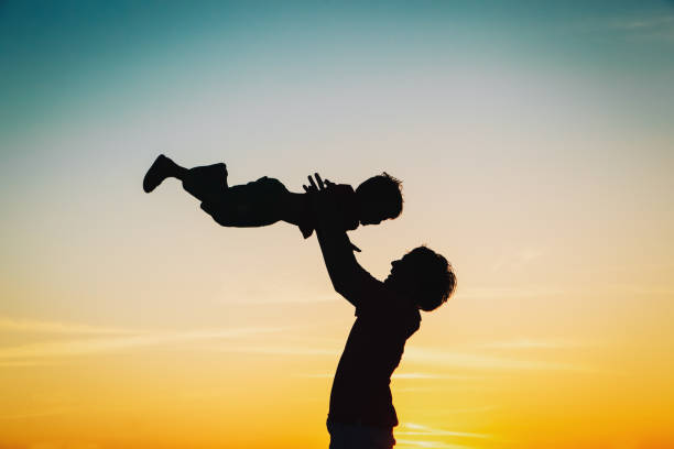 istock father and little son silhouettes play at sunset 664908988