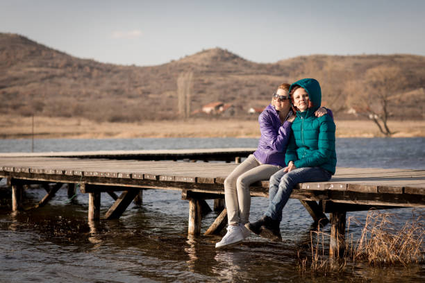 istock sisters enjoying in windy day on lake pier 664912684