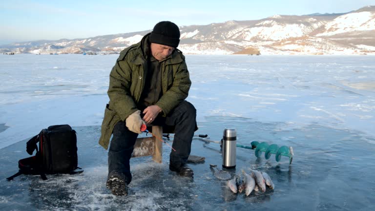 Fisherman is a man in winter fishing.