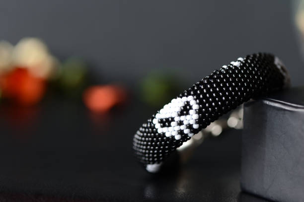 istock Beaded bracelet with a skull image on a dark background 664917170