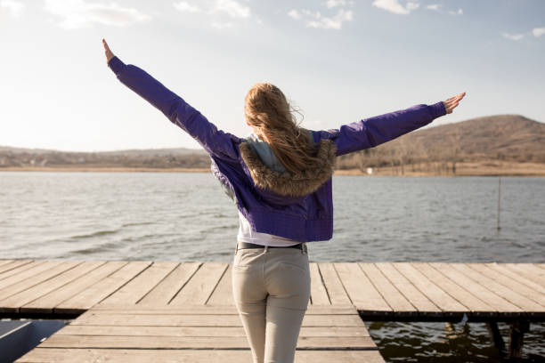 istock Young woman on lake pier 664919398