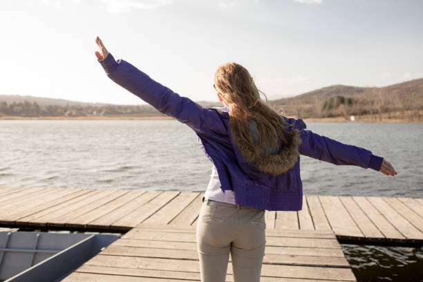 istock Young woman on lake pier 664922658