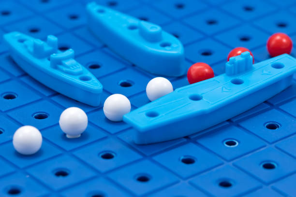 istock Toy war ships and a submarine lined up to play 664928130