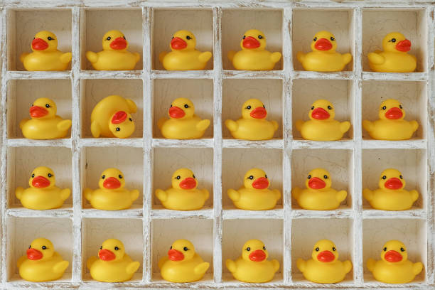 istock Many individual yellow rubber ducks in pigeon hole compartments with one duck upside down. 664934550