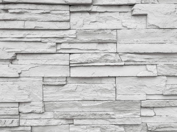 istock Closeup surface brick pattern at old stone brick wall textured background in black and white tone 664940190