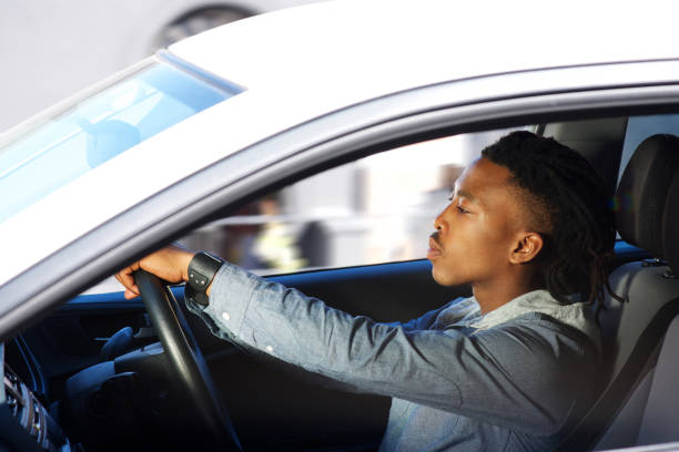 istock young black man driving car 664940298