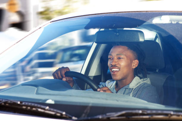 istock smiling african man driving car in city 664940410