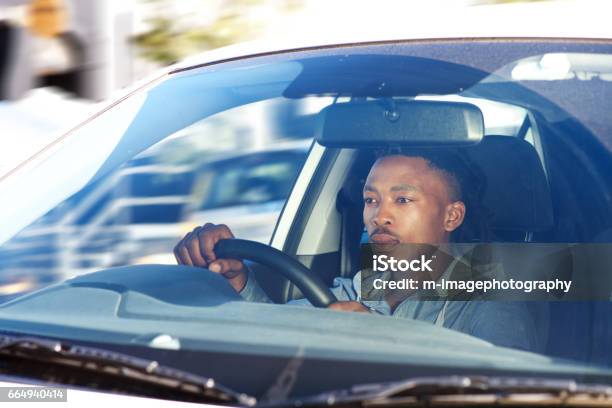 african man driving car in city