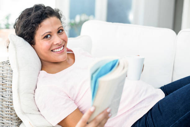 istock Pregnant woman with book holding coffee 664946492