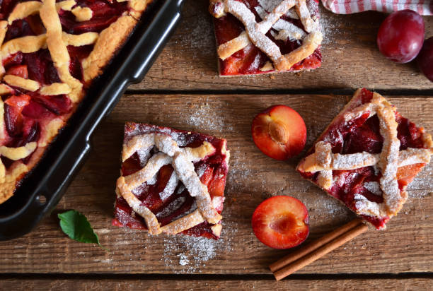 istock Sand cake with plums on a wooden background with space for text 664947172