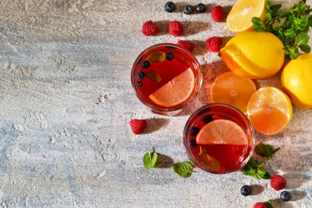 istock Cold berry drink with lemon and mint on a concrete background 664947256
