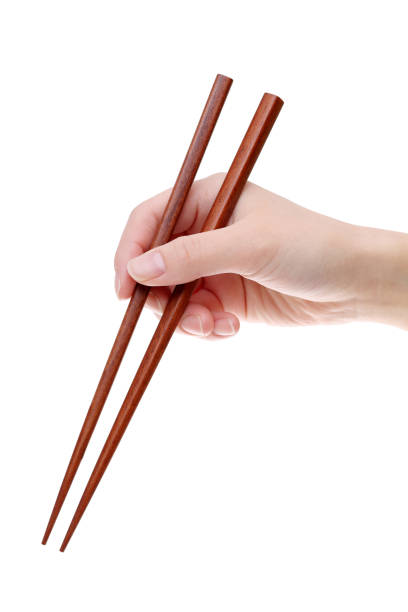 hand holding wooden chopsticks - hashis imagens e fotografias de stock