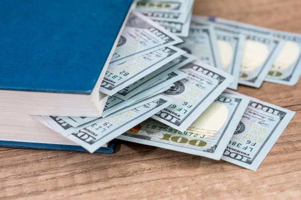 istock us 100 dollar in book on desk. 664950816