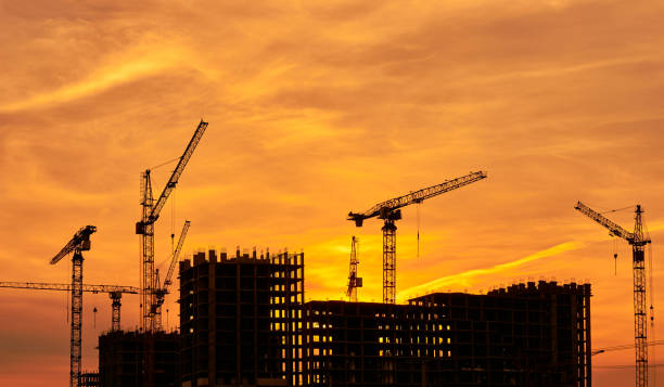 istock Construction site at dusk evening yellow back light, silhouette cranes, sunlight 664951672