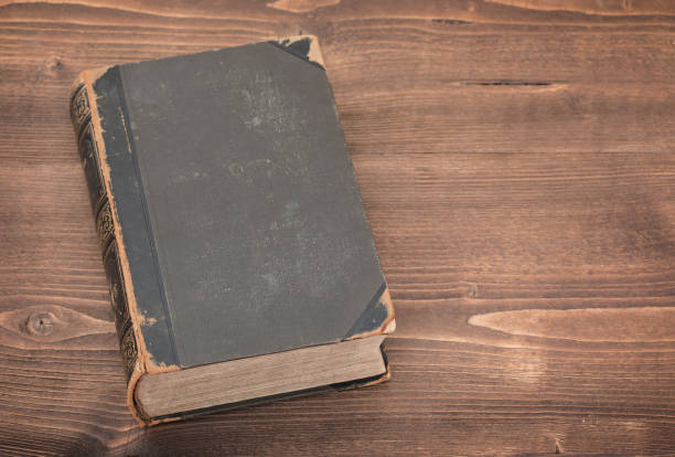 istock Old book on wooden background 664953720