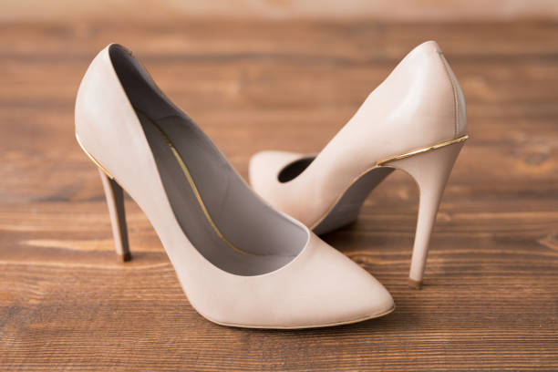 istock Nude high heels on wooden background 664953918