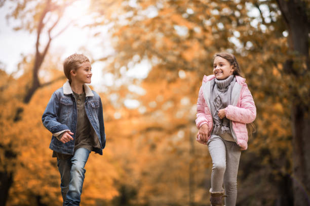 istock Playful children having fun while running in autumn. 664962034