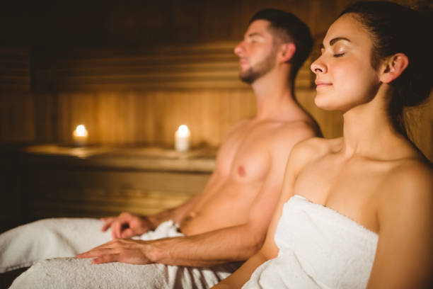 Happy couple enjoying the sauna together Happy couple enjoying the sauna together at the spa sauna stock pictures, royalty-free photos & images