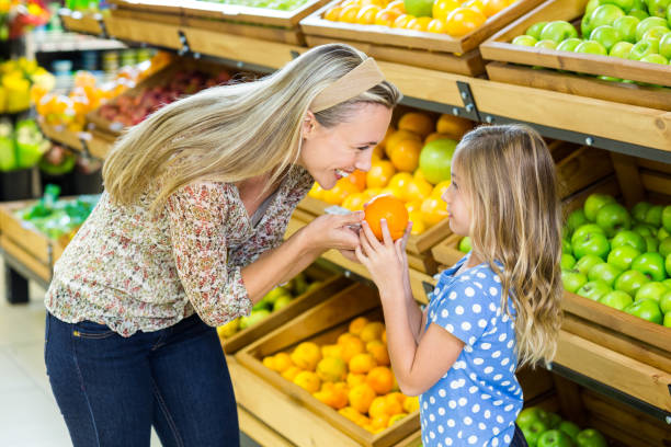 istock Mother and daughter holding orange 664962850