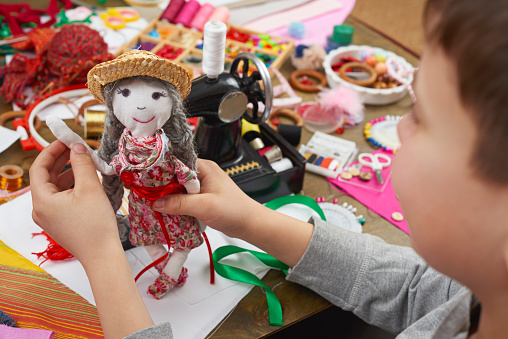 boy tailor learns to sew, dress for doll, handmade and handicraft concept