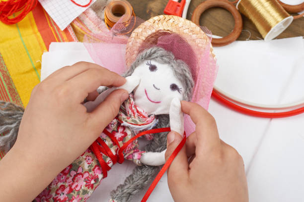 istock child hand making dress for handmade doll, learn to sewing 664963372