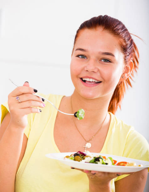istock teenager eating salad 664966340