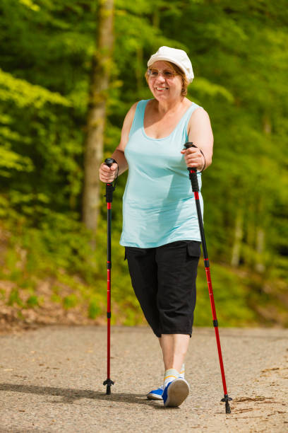 istock Senior woman practicing nordic walking in park 664967140