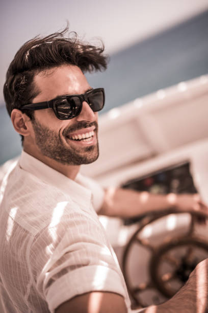 istock Young smiling man driving a boat in summer day. 664971498