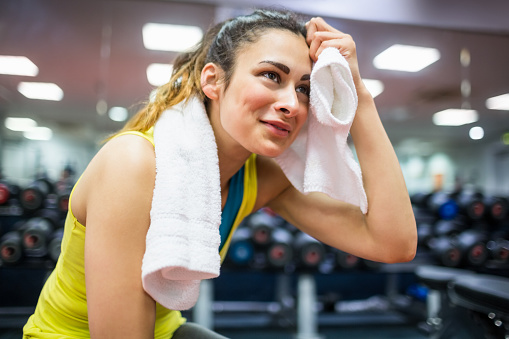 Woman drying her forehead from a workout at the gym