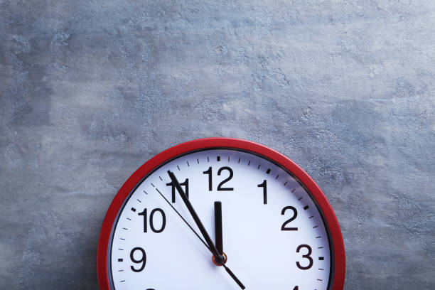 istock Red round clock on a grey wooden table 664972614