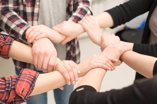 istock A group of young people hold strong hands. 664976856