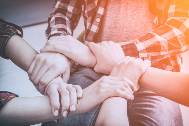 istock A group of young people hold strong hands. 664979506