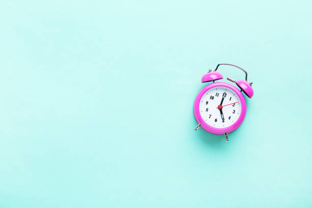 istock Pink alarm clock on the mint background 664980766