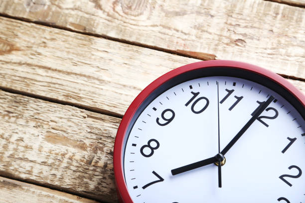 istock Red round clock on a grey wooden table 664982970