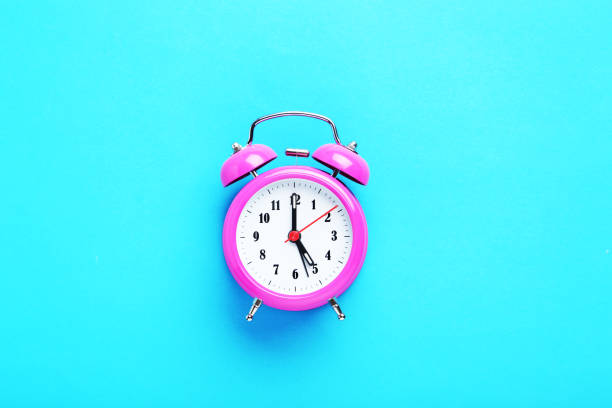 istock Pink alarm clock on the mint background 664984310