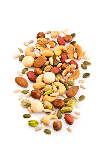 Vertical shot of mixed nuts arranged in a heap isolated on white background. Nuts included in the composition are pistachios, hazelnut, pine nut, almonds, pumpkin seeds, macadamia nuts, sunflower seeds, peanuts, cashew and walnuts. DSRL studio photo taken with Canon EOS 5D Mk II and Canon EF 100mm f/2.8L Macro IS USM