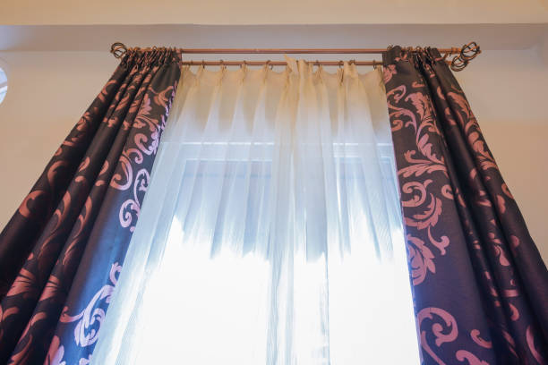 istock Bottom view of brown colored curtains opened rail and sunlight 664987710