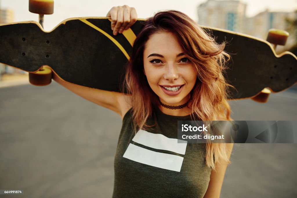 Hermosa joven tatuada con longboard en tiempo soleado - Foto de stock de Adolescente libre de derechos