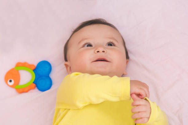 istock Happy baby lying in his crib smiling 664994634