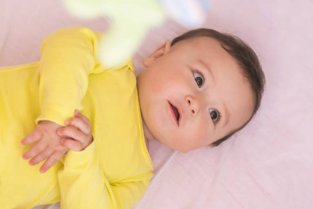 istock Happy baby lying in his crib smiling 664994978