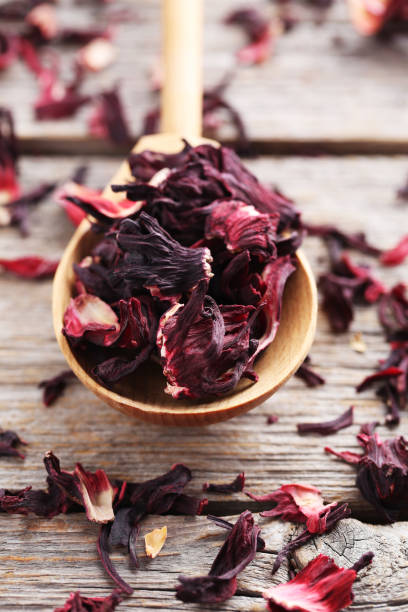 istock Heap of dry tea with wooden spoon on grey table 664995708
