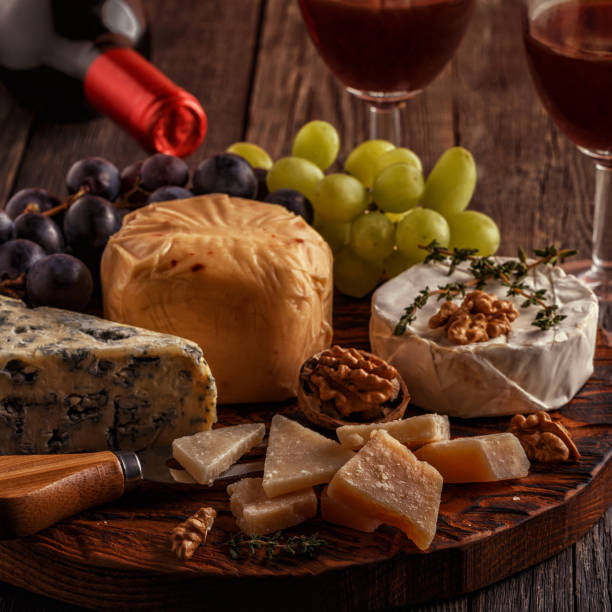 istock Cheese, nuts, grapes and red wine on wooden background 664998082
