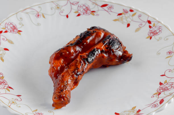 istock Traditional roasted chicken on floral plate over white background 664998232