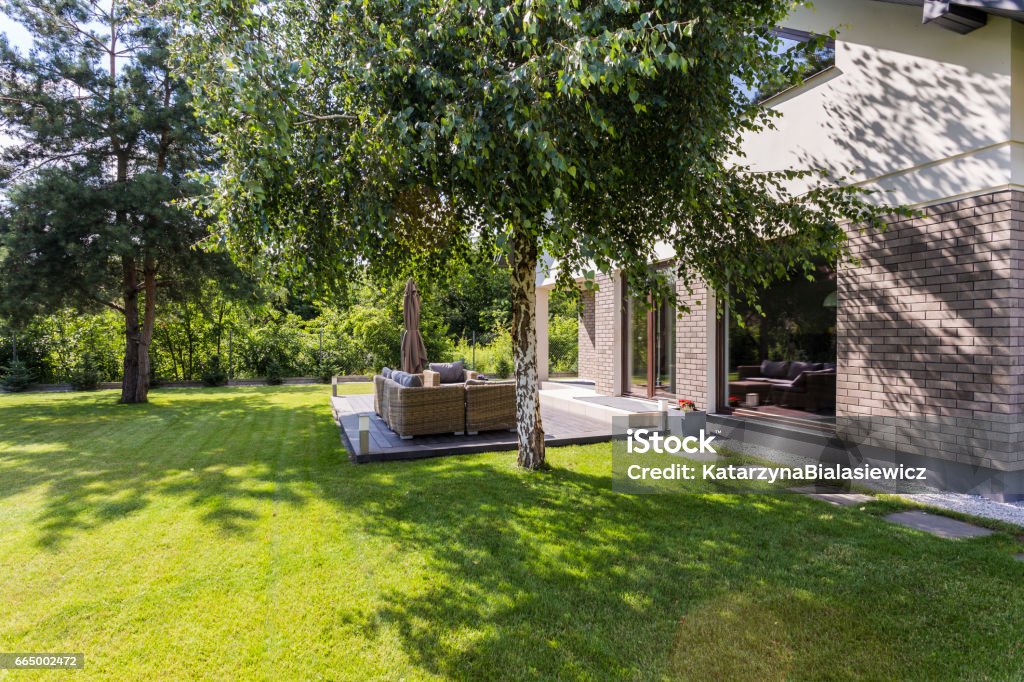 Sunny garden ideal for summer barbecues Green backyard of a modern detached house, with a set of garden furniture Yard - Grounds Stock Photo