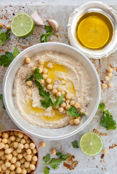 Homemade hummus with olive oil and fresh parsley