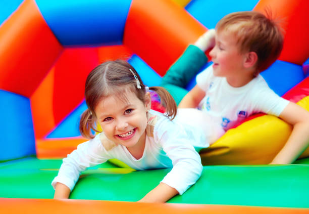 niños felices divirtiéndose en patio en jardín de la infancia - inflable fotografías e imágenes de stock